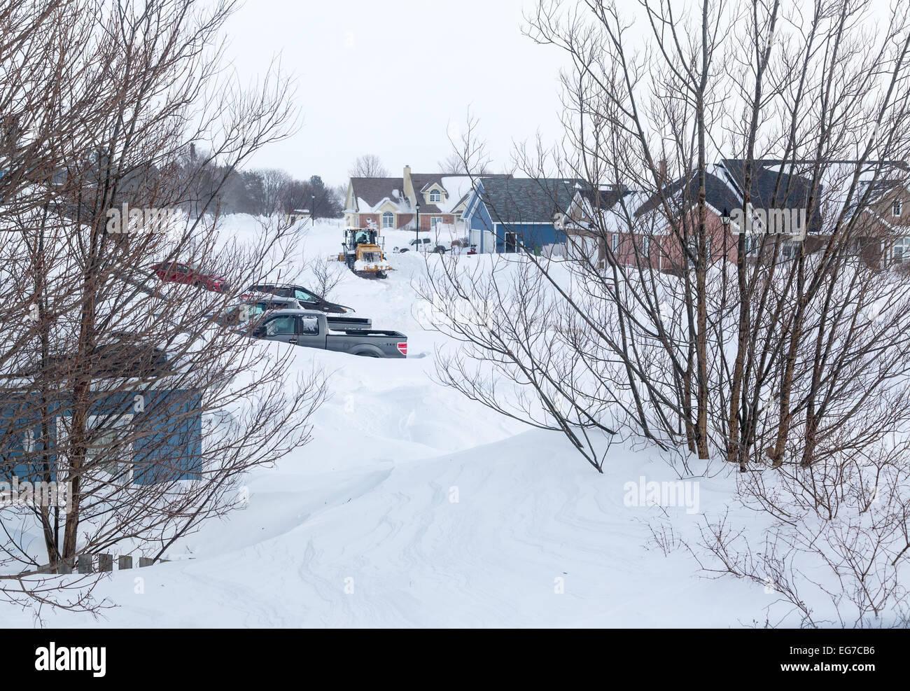 Snow plow plowing a suburban street in a North American city after a