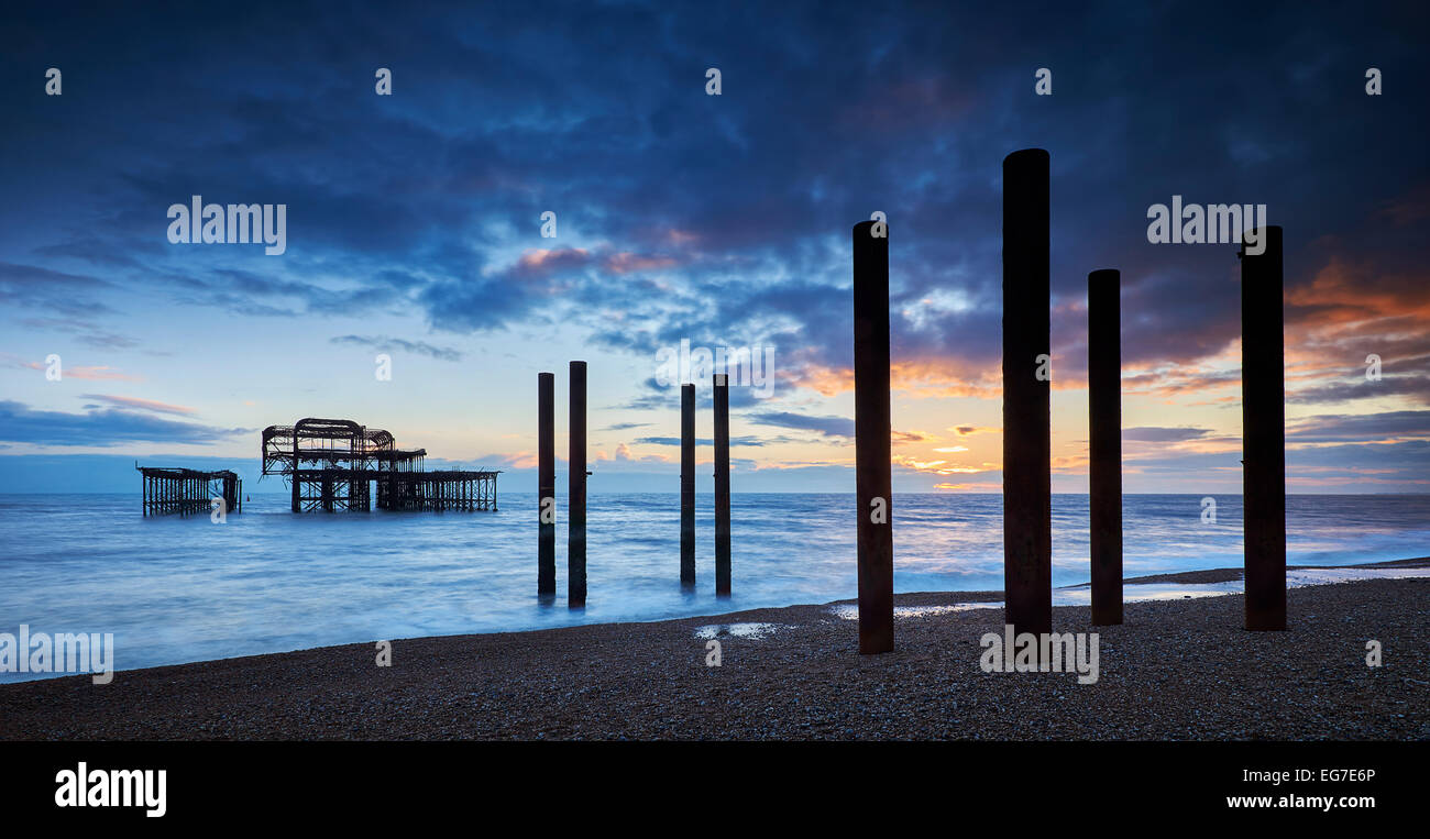 The decaying remains of Brighton's West Pier at sunset with the tide coming in. Stock Photo