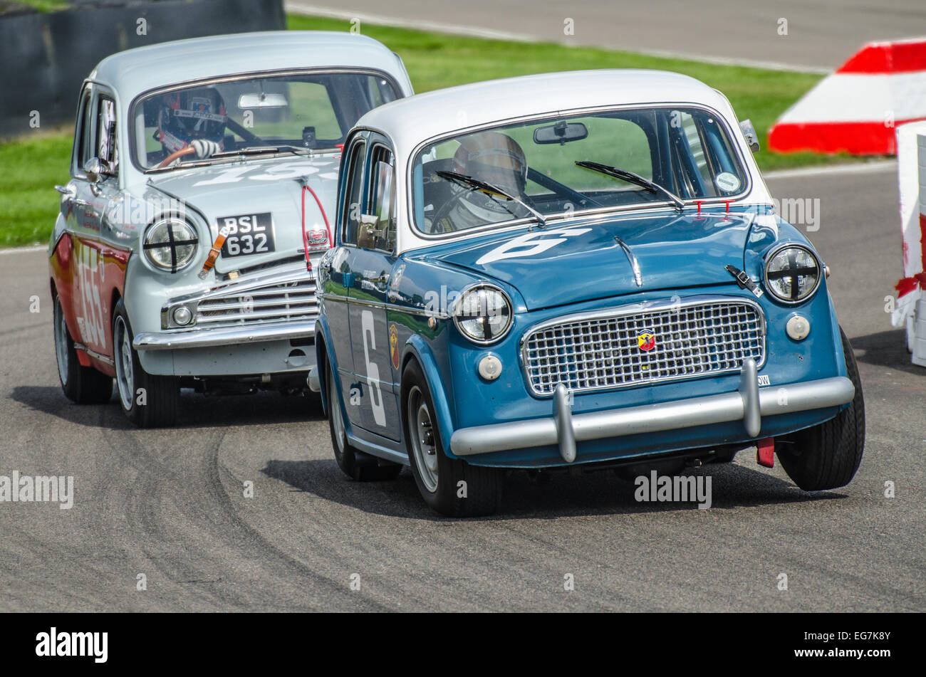 Fiat 1100 racing at the Goodwood Revival. Vintage motor car racing through the chicane with wheel off the ground Stock Photo