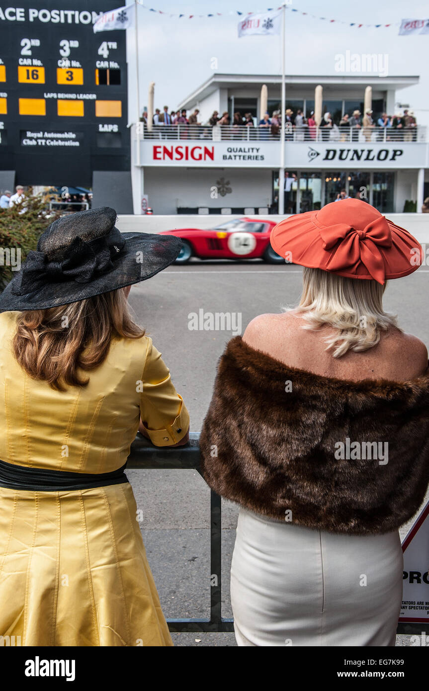 Ladies in period costume watch the Goodwood Revival. Females watching vintage motor racing with pits area and lap board Stock Photo