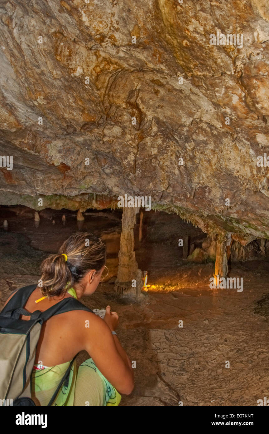 Woman admiring stalactites in cave Stock Photo