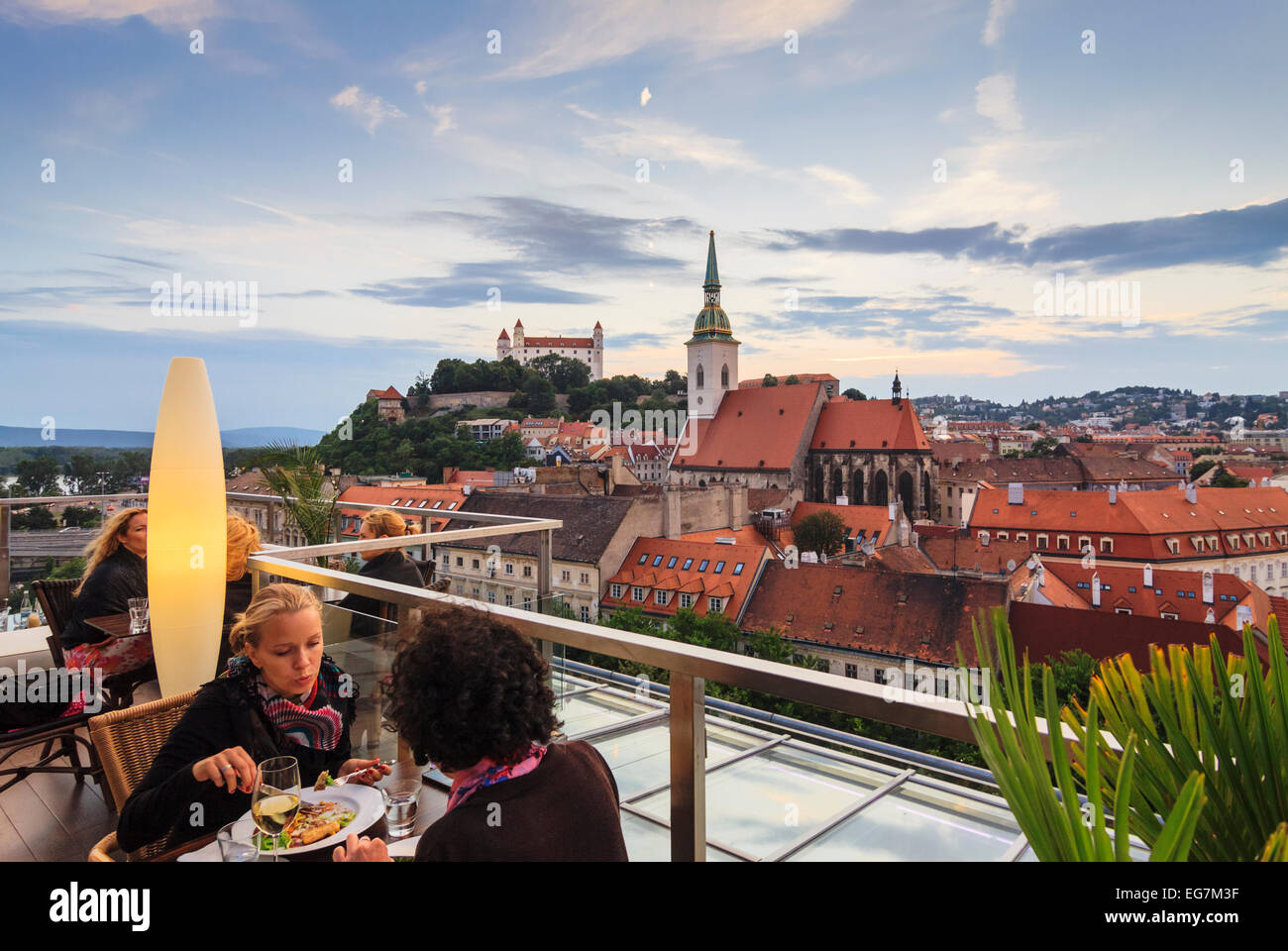 Women at panoramic terrace of Sky restaurant overlooking old town, cathedral and castle in Bratislava, Slovakia Stock Photo