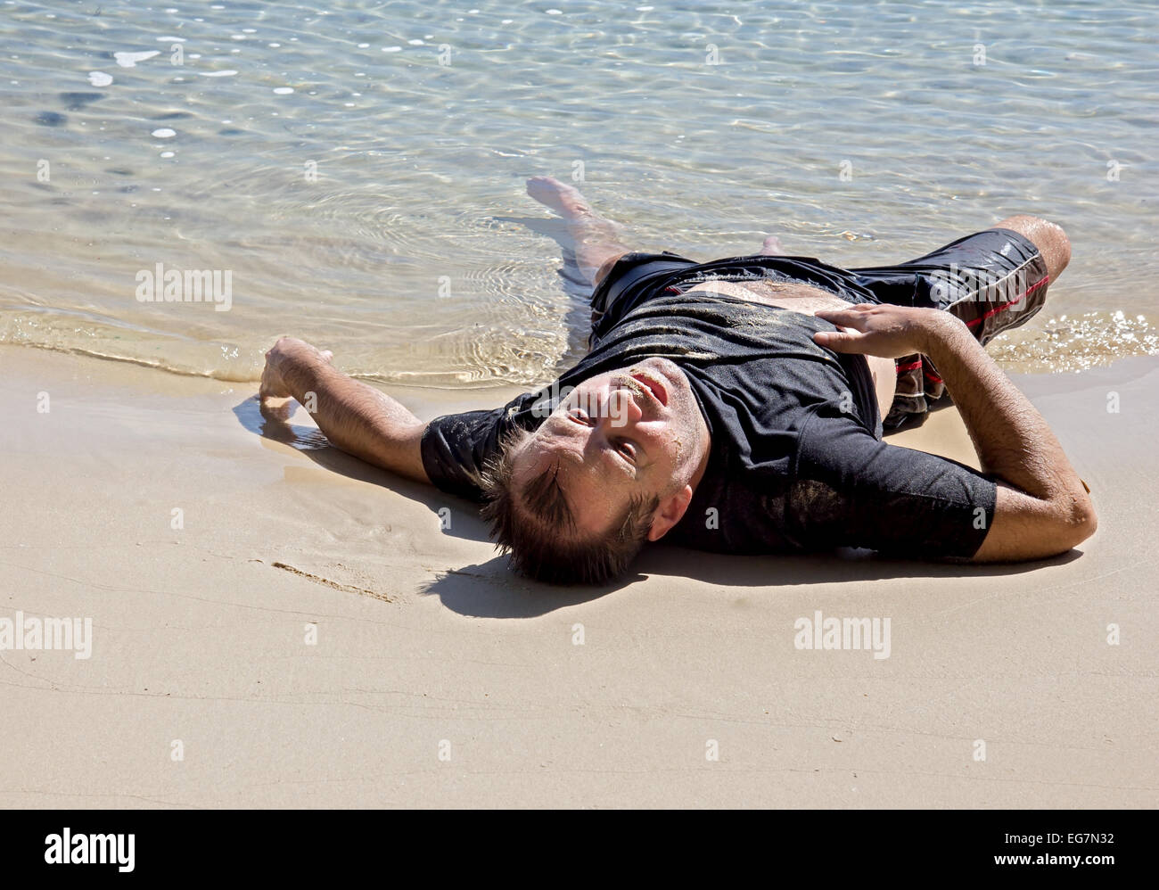 Подъем человека из воды. Человек лежит на пляже. Человек лежит на песке. Человек лежит в воде. Мужчина лежит на пляже.