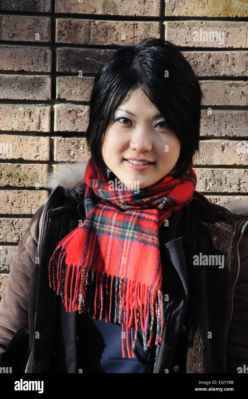 Japanese woman wearing tartan scarf, England, UK Stock Photo