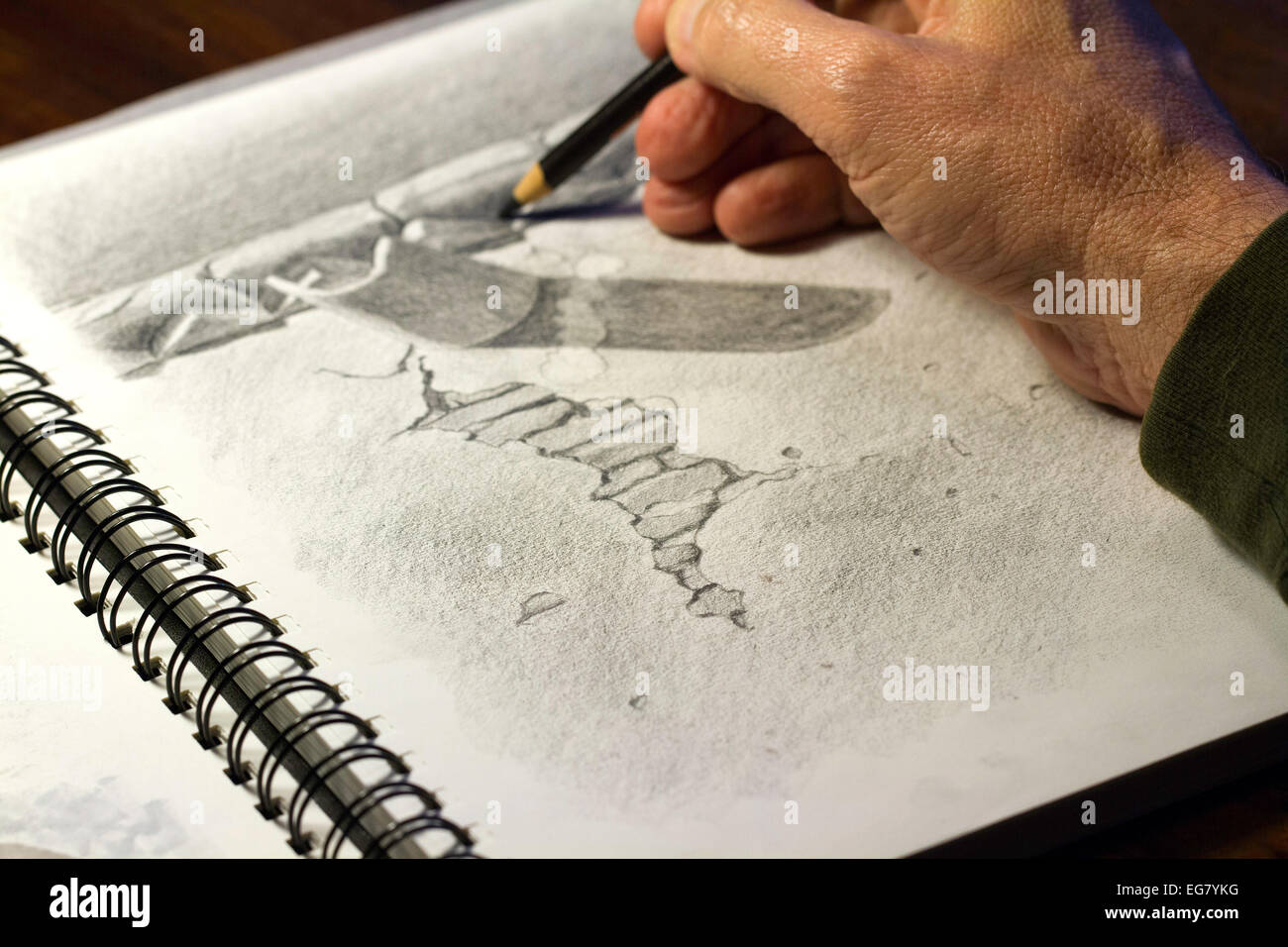 Artist using pencil on paper to draw a picture using lines and shading. Stock Photo
