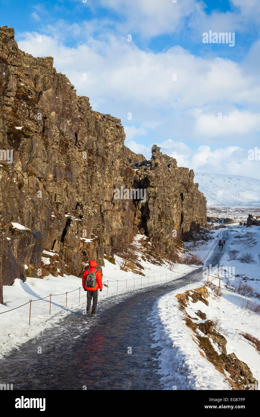 Tourist Hiker in the Allmannagja Gorge Þingvellir National Park in winter Iceland Europe Stock Photo