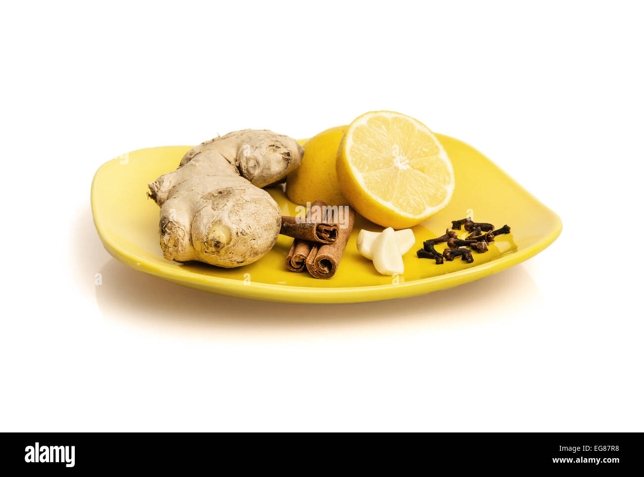 Ginger, cinnamon, lemon, garlic and cloves on the plate. Healthy