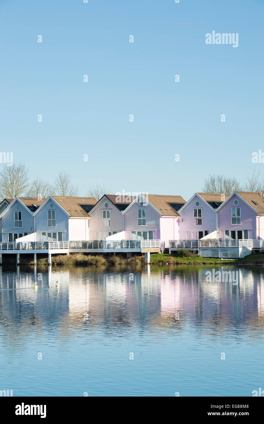 Clapperboard style houses along a lake at the watermark club, Cotswold Water Park, Gloucestershire, England Stock Photo