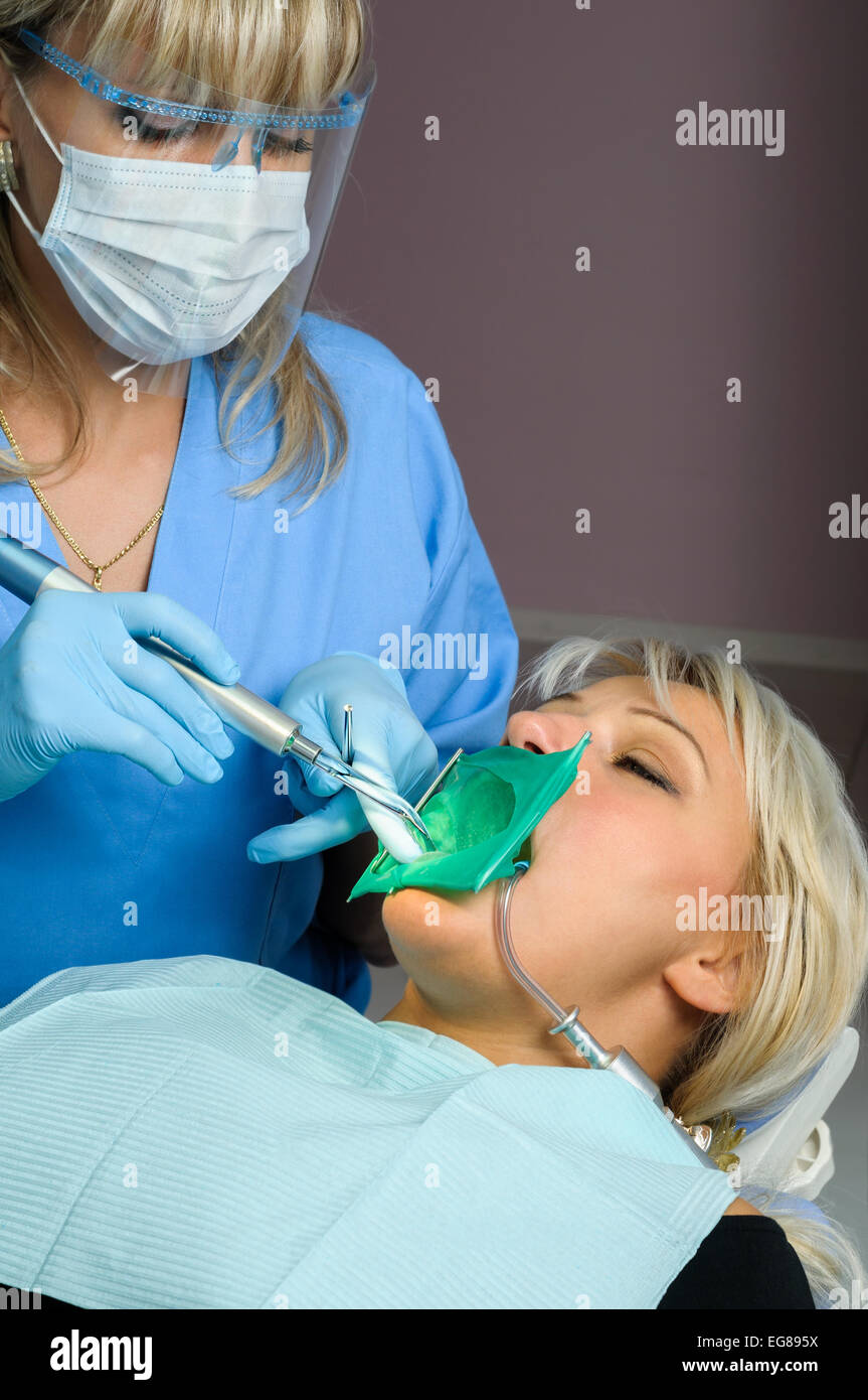 dentist with patient, using dental curing light Stock Photo