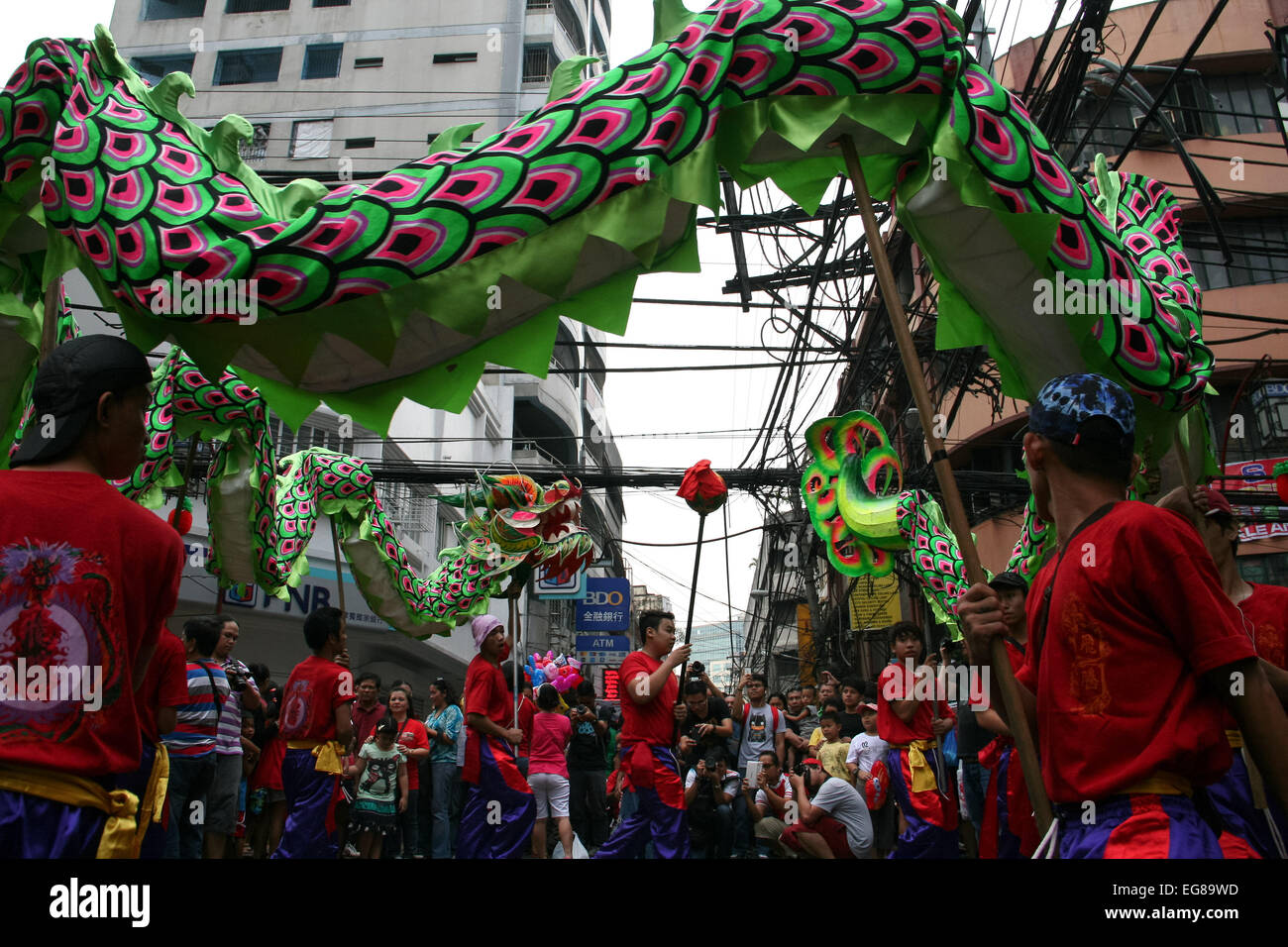 A chinese dragon chases a ball along Ongpin street in Binondo, Manila. Thousands of people joined in the celebration of the Lunar New Year in Binondo, Manila. The Filipino-Chinese community, in the oldest china town in the world, welcomed the year of the wooden sheep with dragon and lion dances. © Gerard Seguia/Pacific Press/Alamy Live News Stock Photo
