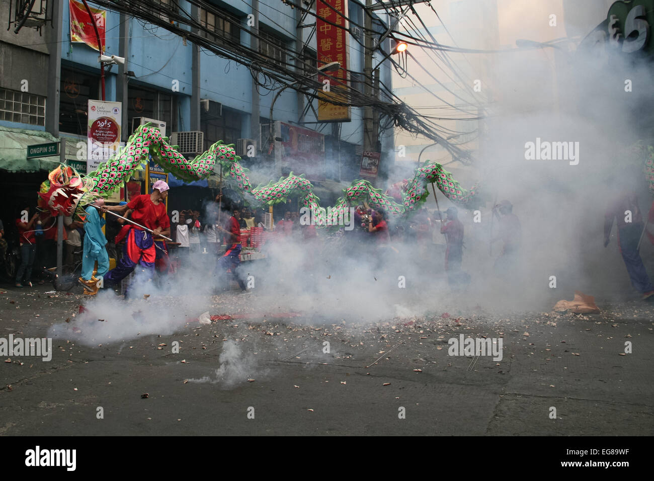 Chinese dragon performers run along exploding firecrakers along Ongpin street in Binondo. Thousands of people joined in the celebration of the Lunar New Year in Binondo, Manila. The Filipino-Chinese community, in the oldest china town in the world, welcomed the year of the wooden sheep with dragon and lion dances. © Gerard Seguia/Pacific Press/Alamy Live News Stock Photo