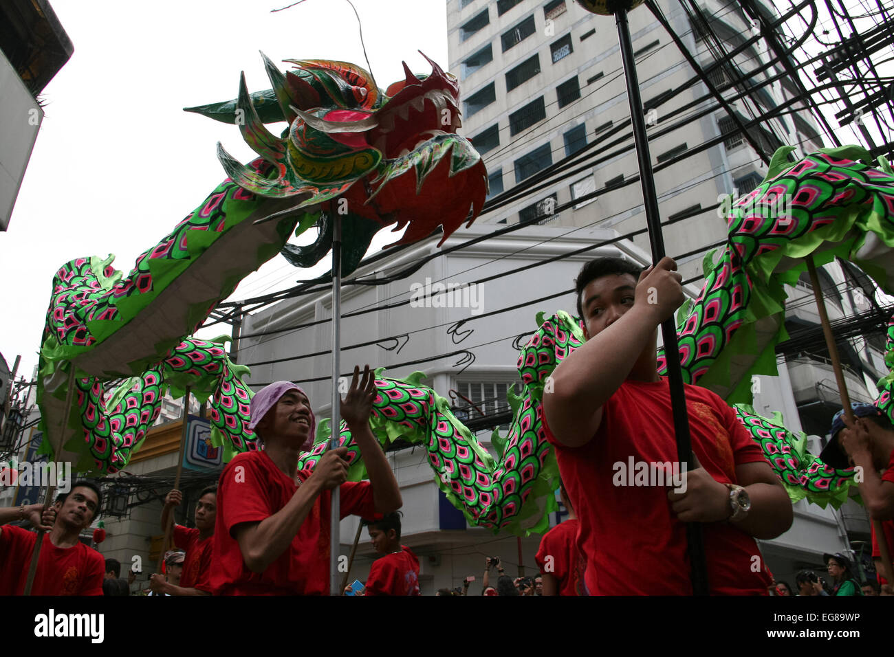 Dragon dancers run along Ongpin street during the Chinese New Year celebration in Binondo, Manila. Thousands of people joined in the celebration of the Lunar New Year in Binondo, Manila. The Filipino-Chinese community, in the oldest china town in the world, welcomed the year of the wooden sheep with dragon and lion dances. © Gerard Seguia/Pacific Press/Alamy Live News Stock Photo