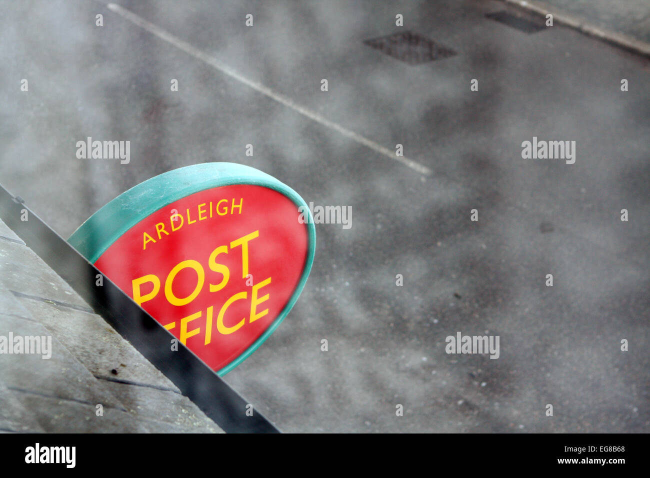 A 'Post Office' sign as seen through windows of the flat above the Post