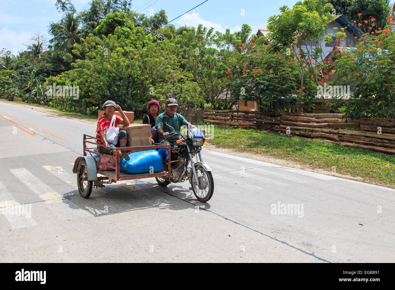 Puerto Princesa, Philippines - January 12,2015: Three people on a tricycle in the Philippines Stock Photo