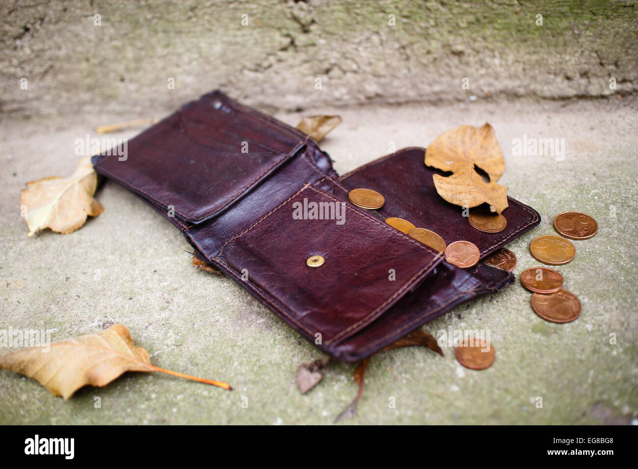 Old wallet with euro coins on concrete floor. Stock Photo