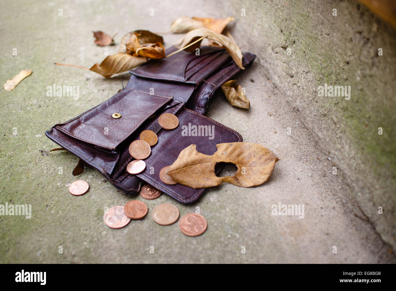 Old wallet with euro coins on concrete floor. Stock Photo