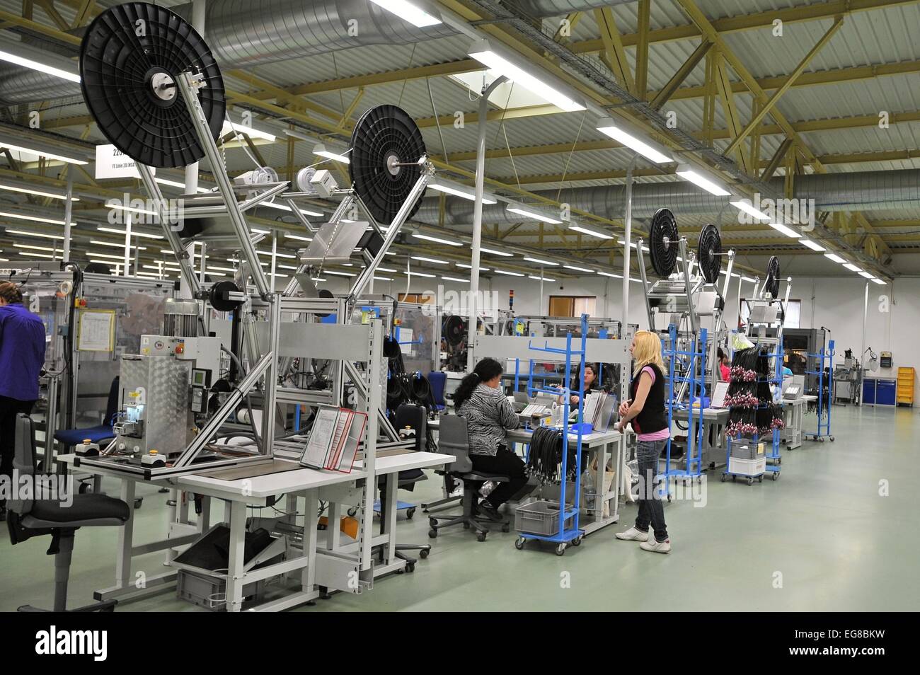 Employees pictured in factory of MD Elektronik Chotesov, which is the leading European producer of multimedia cables for automobiles, in Chotesov, near Pilsen, Czech Republic, February 19, 2015. The company raised sales by a fifth to Kc5.2bn last year, this year plans sales worth Kc5.4bn and its annual profit moves in the order of tens of millions of crowns. By the size of sales, MD Elektronik is the sixth biggest company in the Plzen region and ranks among the top 100 firms in the country. The company with 2,950 employees produces 40,000 kinds of cables. It has been expanding for twenty years Stock Photo