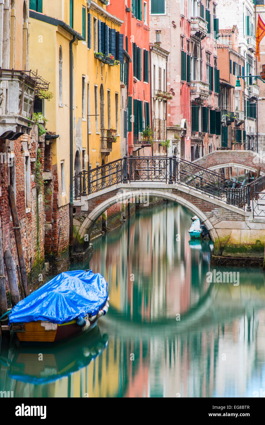 Colorful buildings and stone bridge reflected into a water canal, Venice, Veneto, Italy Stock Photo