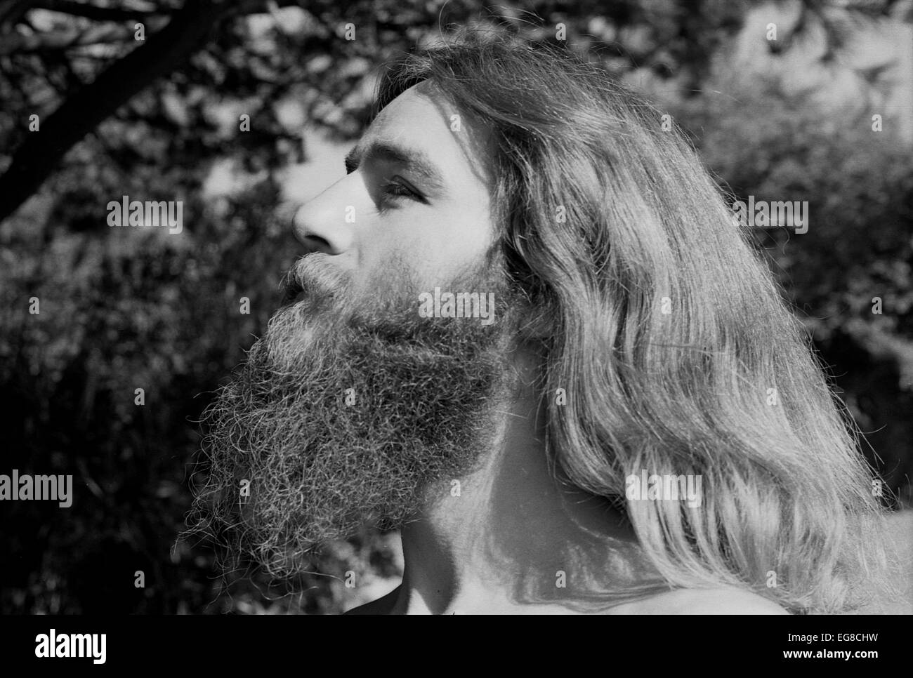 Portrait of hairy hippie man male hippy with a beard and long hair being spiritual spirituality in Berkeley, California USA 1970s 1971  KATHY DEWITT Stock Photo
