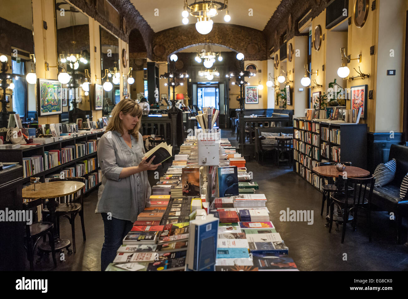 Trieste, Italy - A woman leafs through a book at the newly refurbished bookshop section of Caffe San Marco Stock Photo