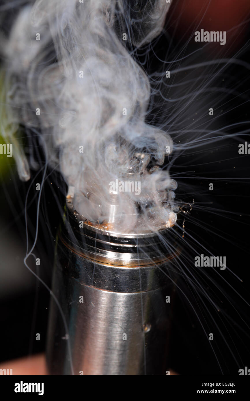 Vapor spews from  a mod-type e-cigarette in action. Stock Photo