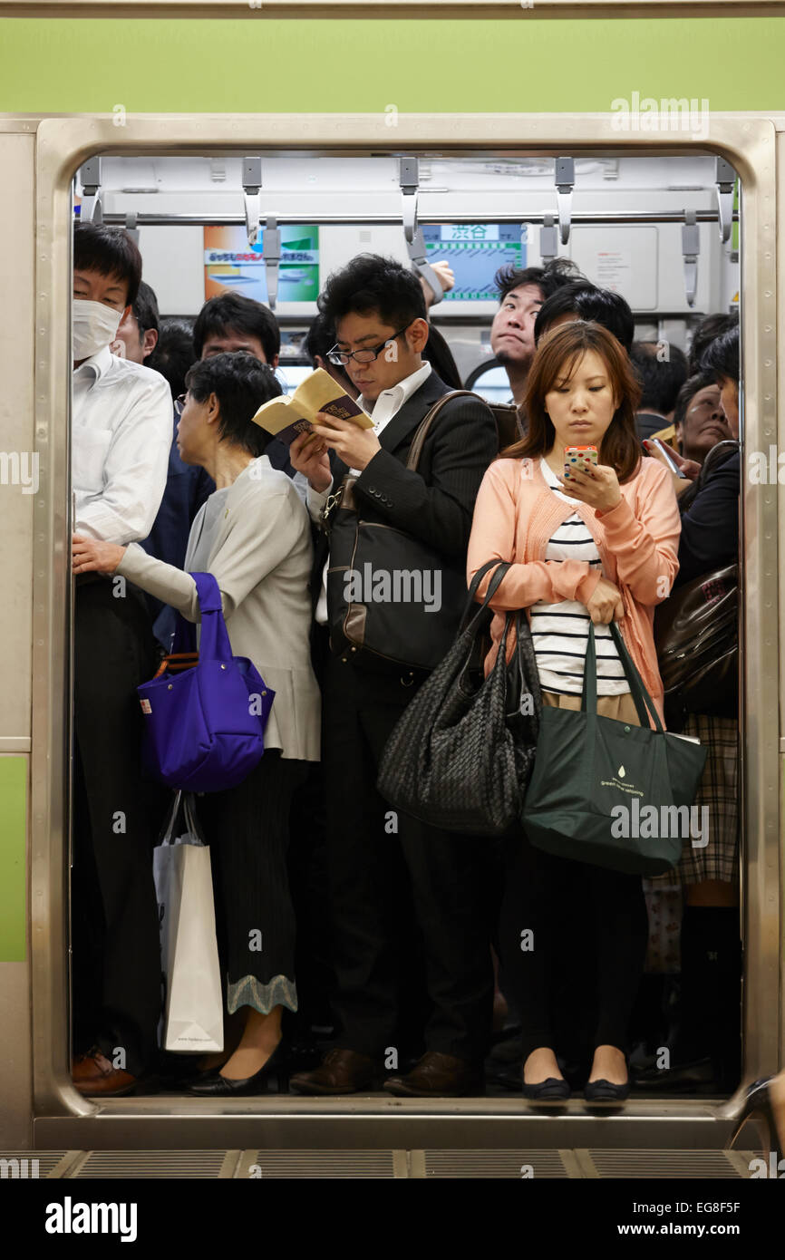 Communters squeezing onto train, Tokyo, Japan Stock Photo
