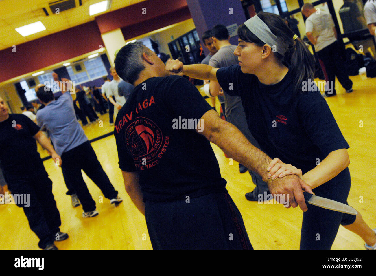 Pictures of Krav Maga:  a mode of self defence practised and made popular by the Israeli military based on a combo of Karate , Jujitsu Judo and Kung Fu  - dark haired girl swaps roles with trainer Mike demonstrating a number of attack/defence situations - more professional people and women in particular are taking up these kinds of classes perhaps in a response to increase in physical violence on London streets  shoot location 'Fitness First' london w1 20 may 2007 published 11 June 2007  commission the london lite pictured trainer Mike Kapsalis  Mike and students model released www.kravmagalon Stock Photo