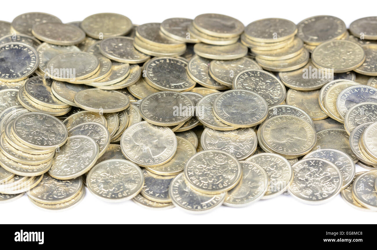 Large pile of old British sixpence coins from 1967 on a white background. 6d coins, known as a Tanner. Stock Photo