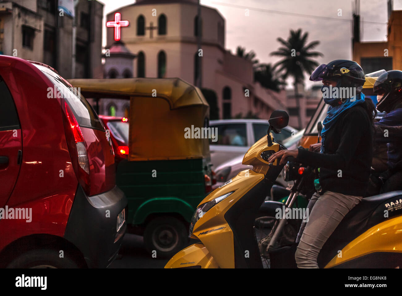 Woman wearing scarf on moped in traffic in modern southern India (Bangalore). Stock Photo