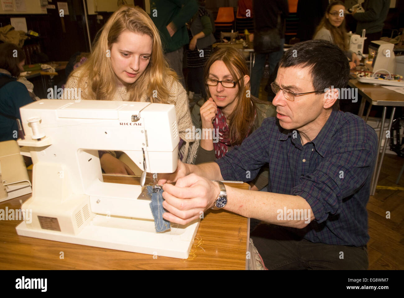 Young woman (far left) at a Repair Cafe getting her sewing machine