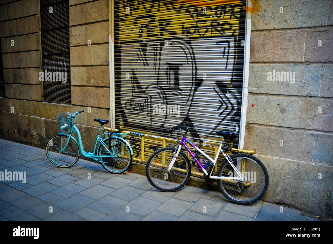 Barcelona Spain bicycles on narrow street with graffiti Stock Photo