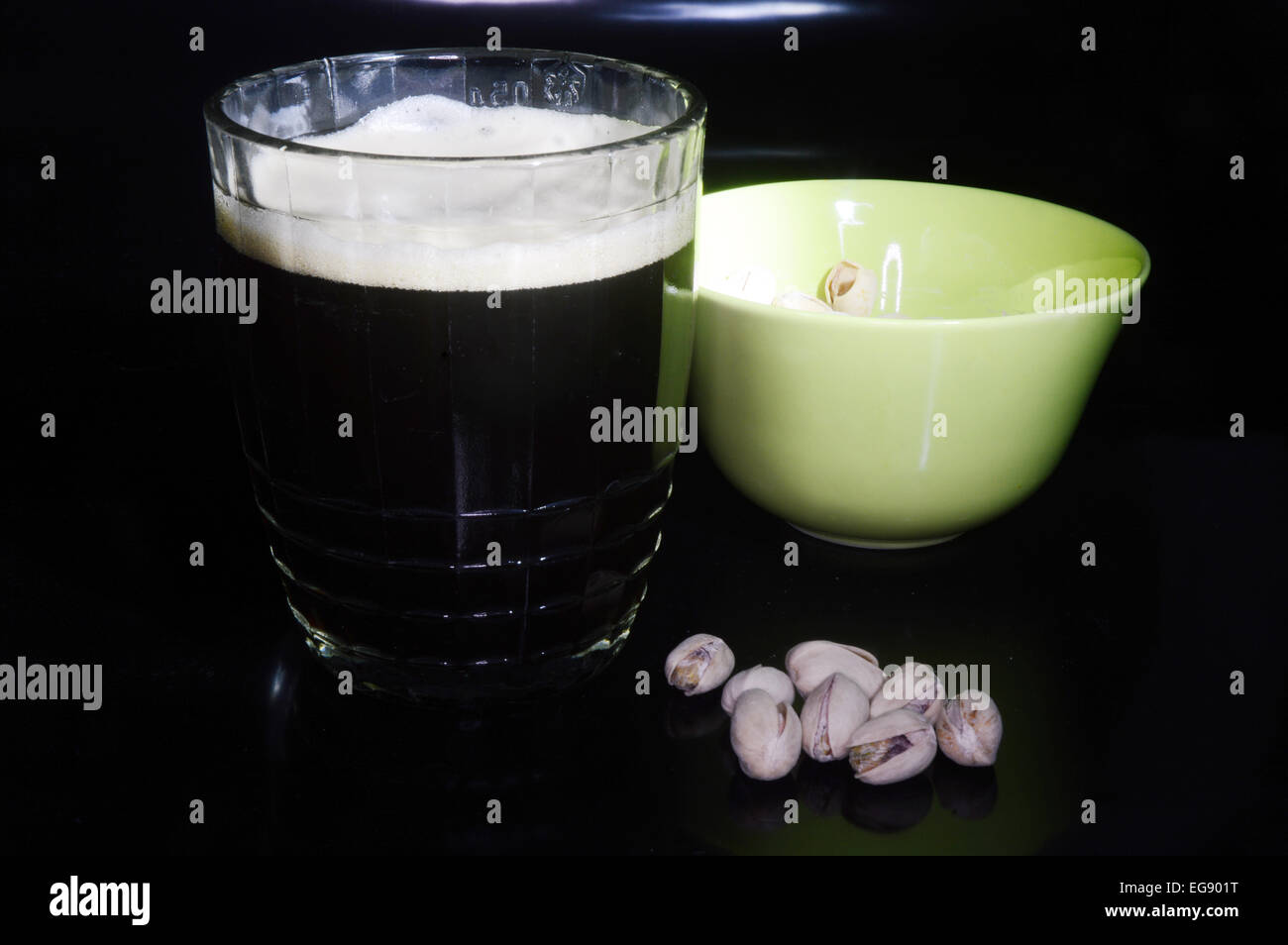 Dark beer and pistachios on a black background Stock Photo