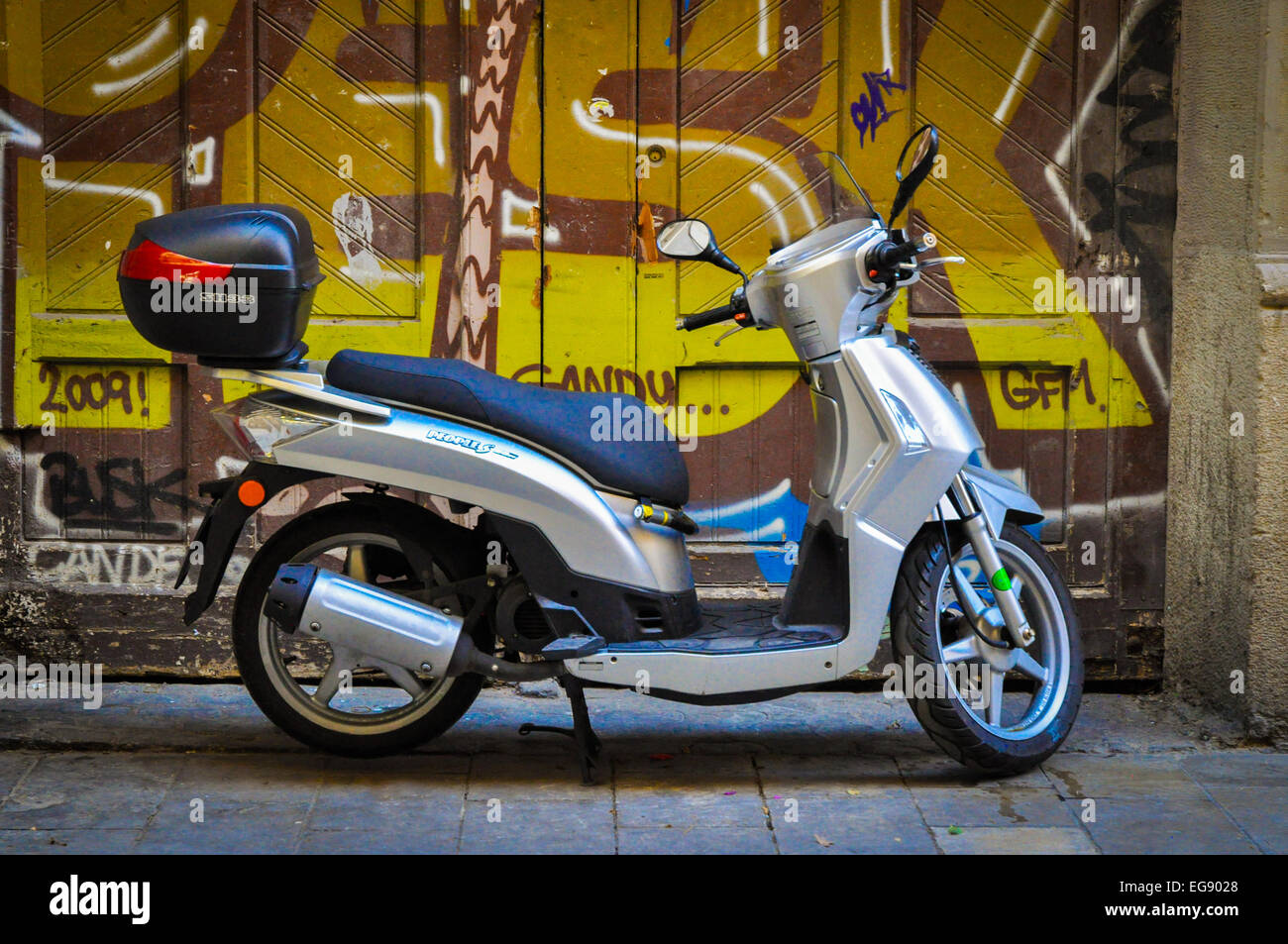 motor scooter in front of graffitied doorway Barcelona Spain Stock Photo