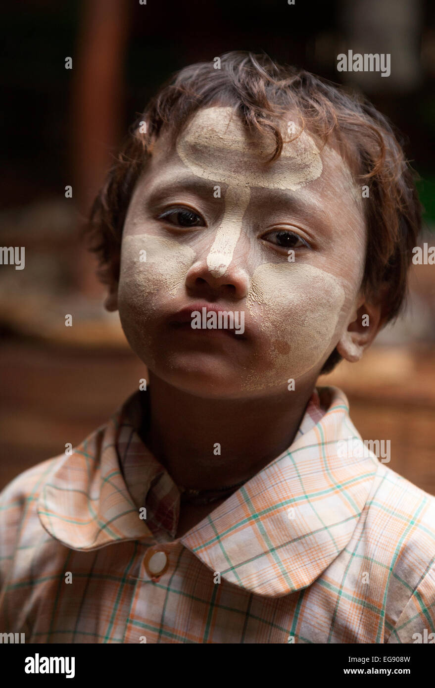 Head and shoulders portrait of a young asian boy child wearing traditional thanaka paint for sun protection, Myanmar Burma Asia Stock Photo
