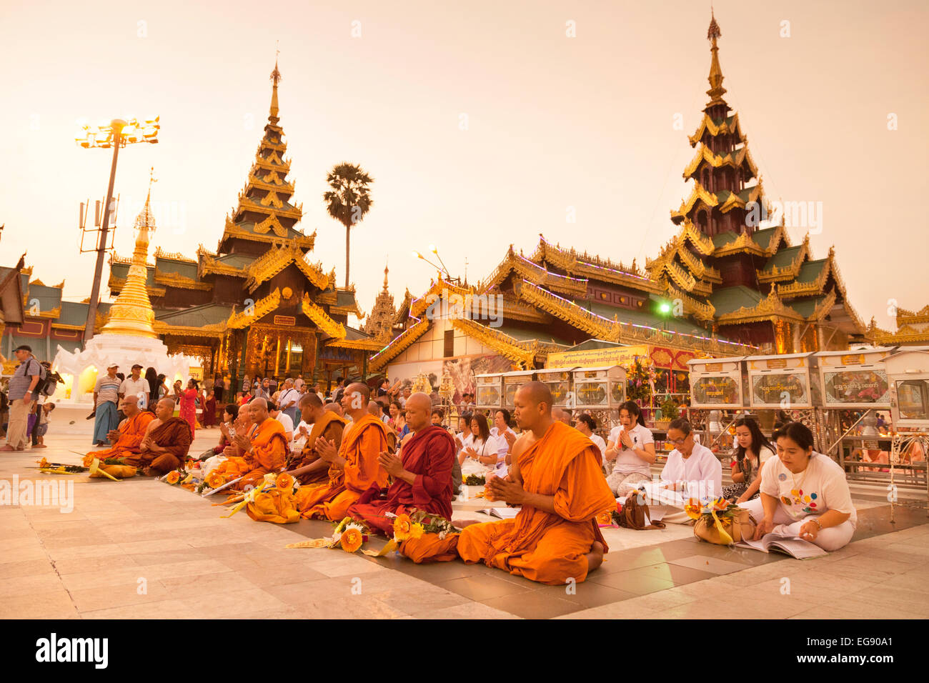 Buddhist monks and local people worshipping at the Shwedagon Pagoda