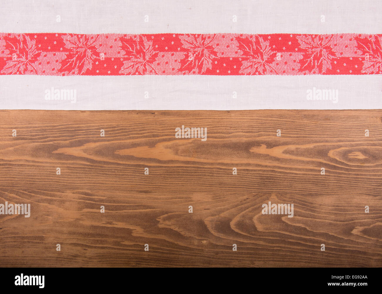 Old red and white patterned kitchen towel on dark wooden background Stock Photo
