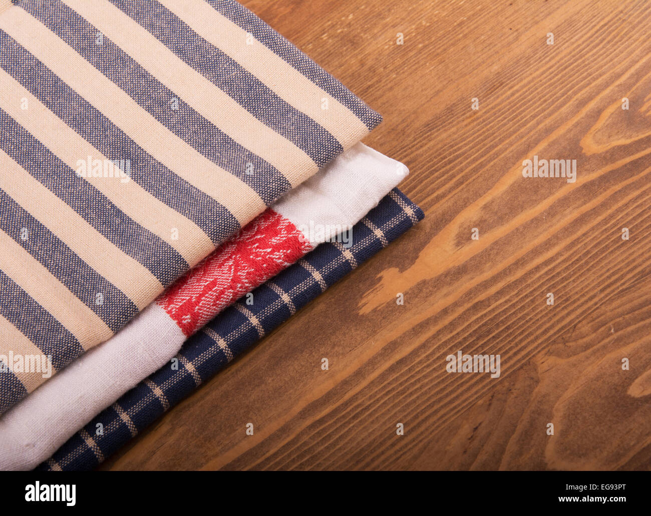 Old linen kitchen towels folded on dark wooden table Stock Photo
