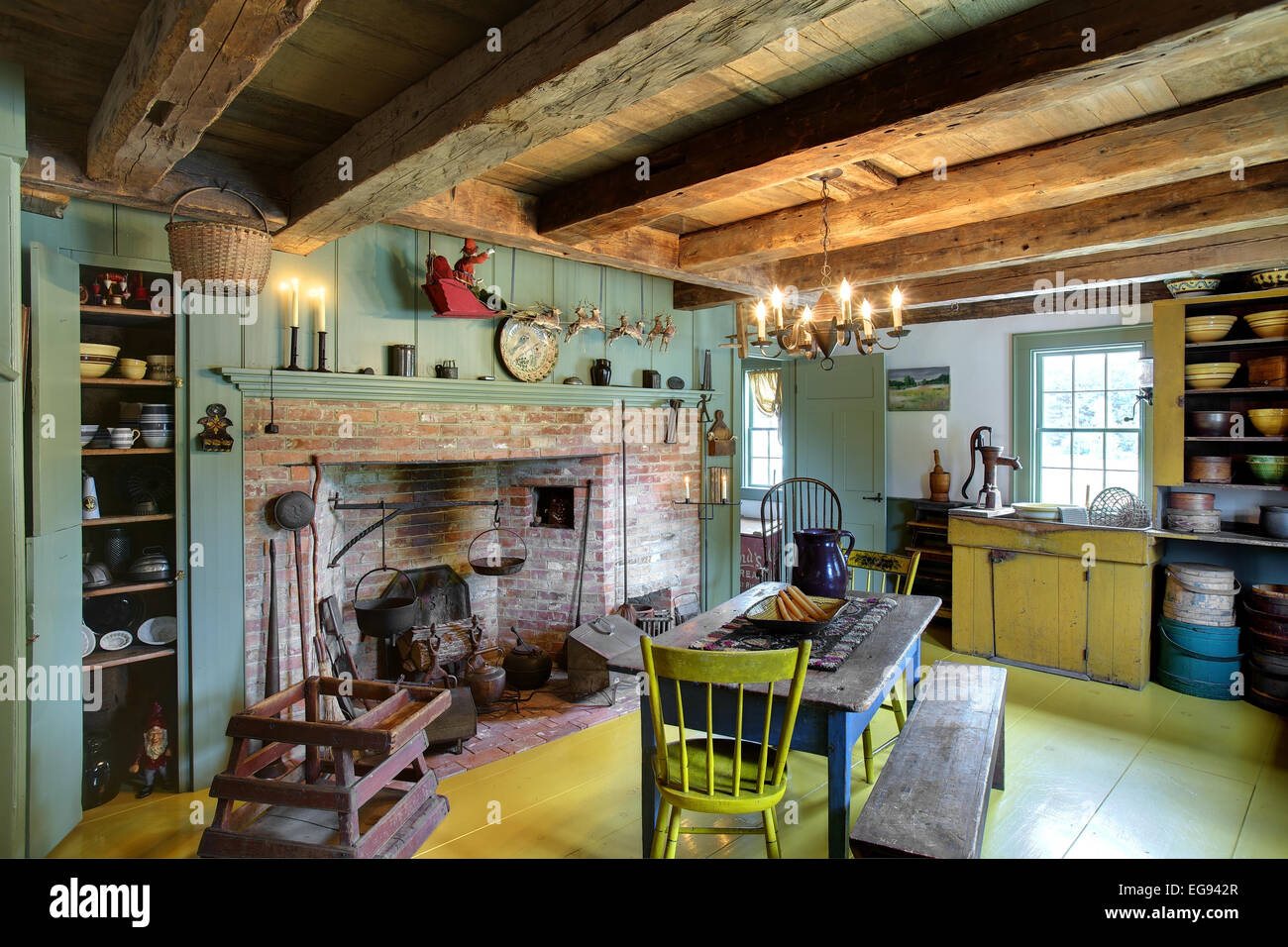The kitchen, dining room and fireplace in a restored 17th century primitive colonial style home. Stock Photo