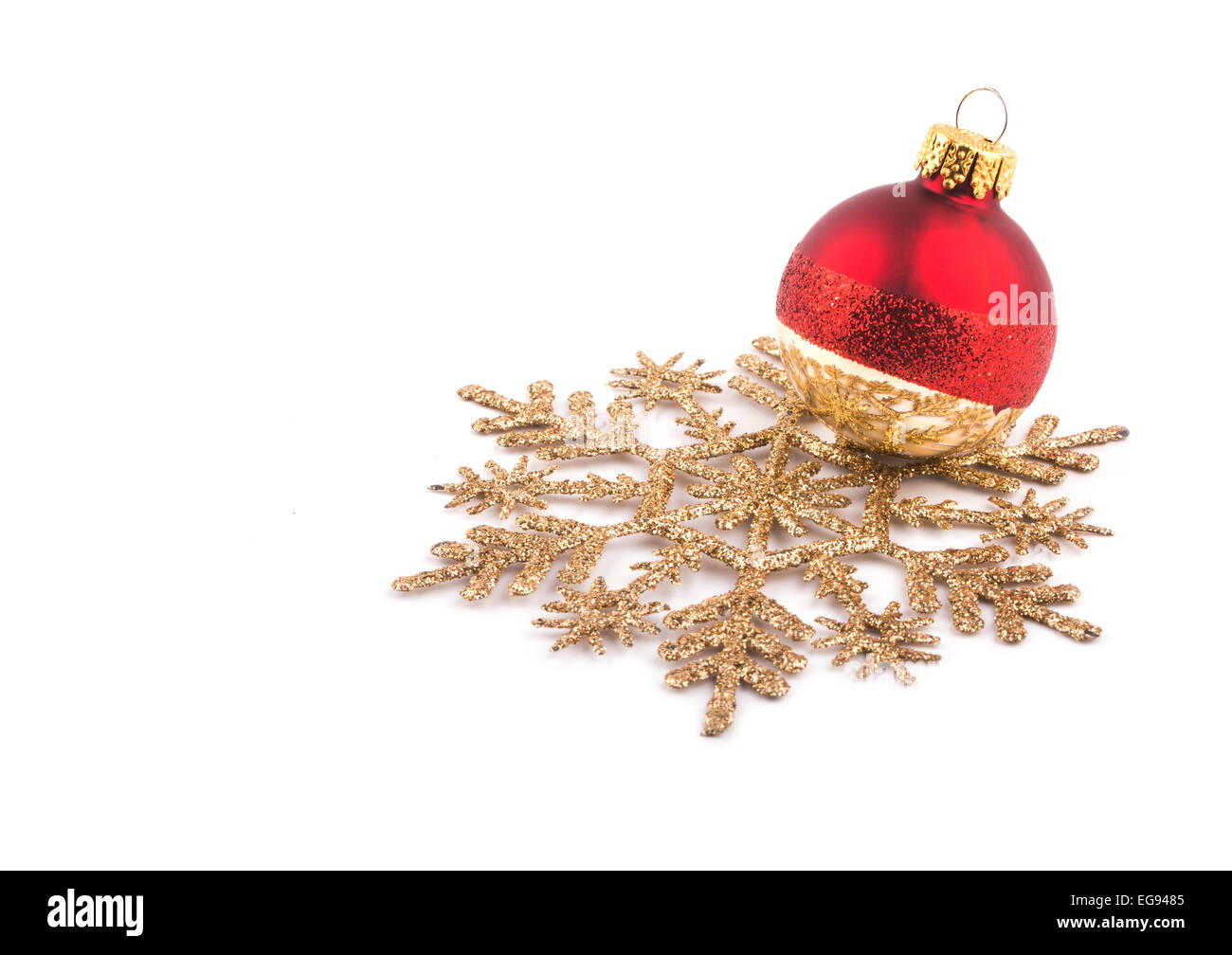 Christmas bauble resting on a golden snowflake, on white Stock Photo