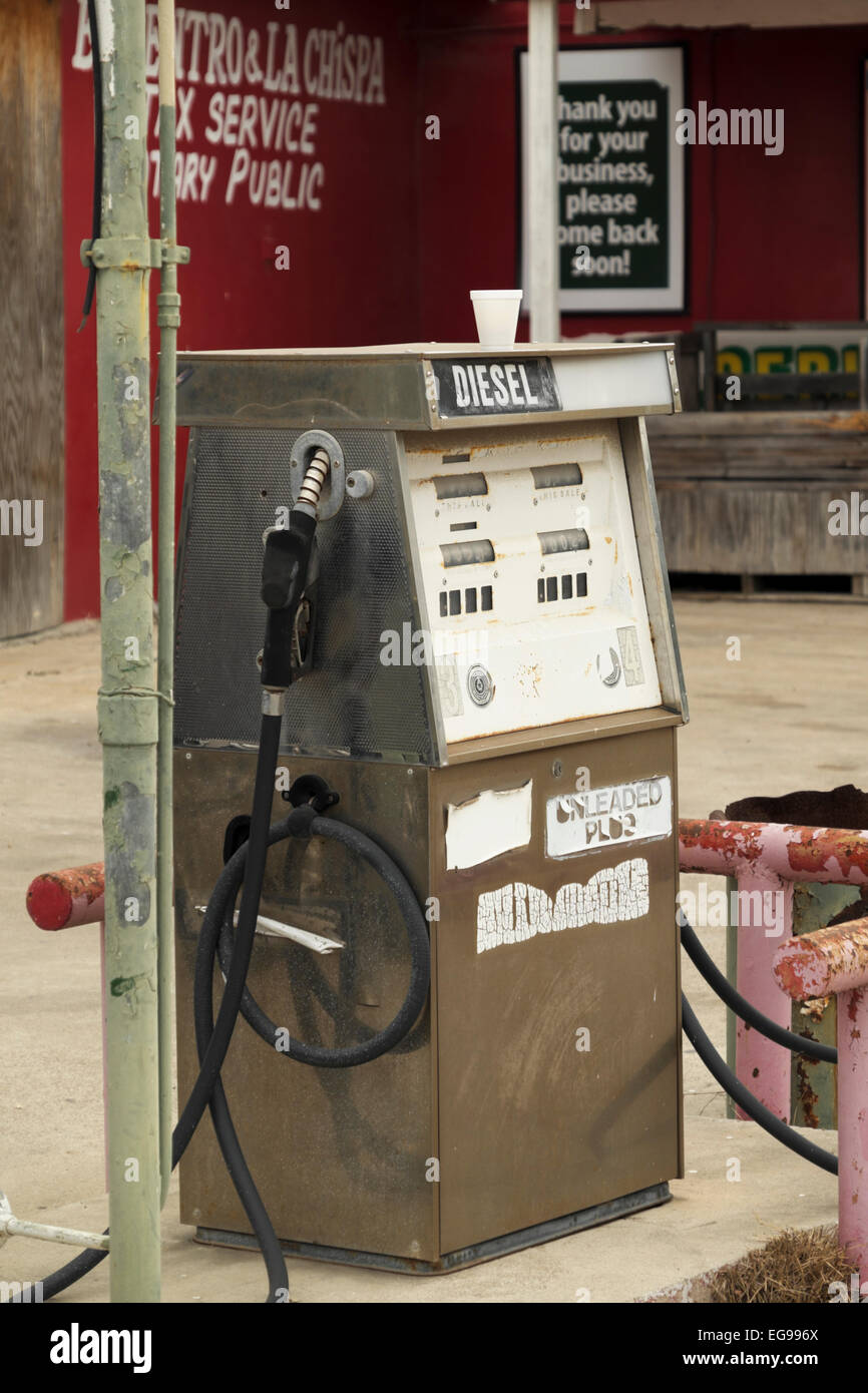 An old, deteriorating fuel pump sits on a corner lot in downtown