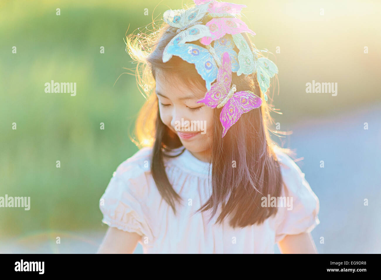 Girl (8-9) with butterflies in hair Stock Photo