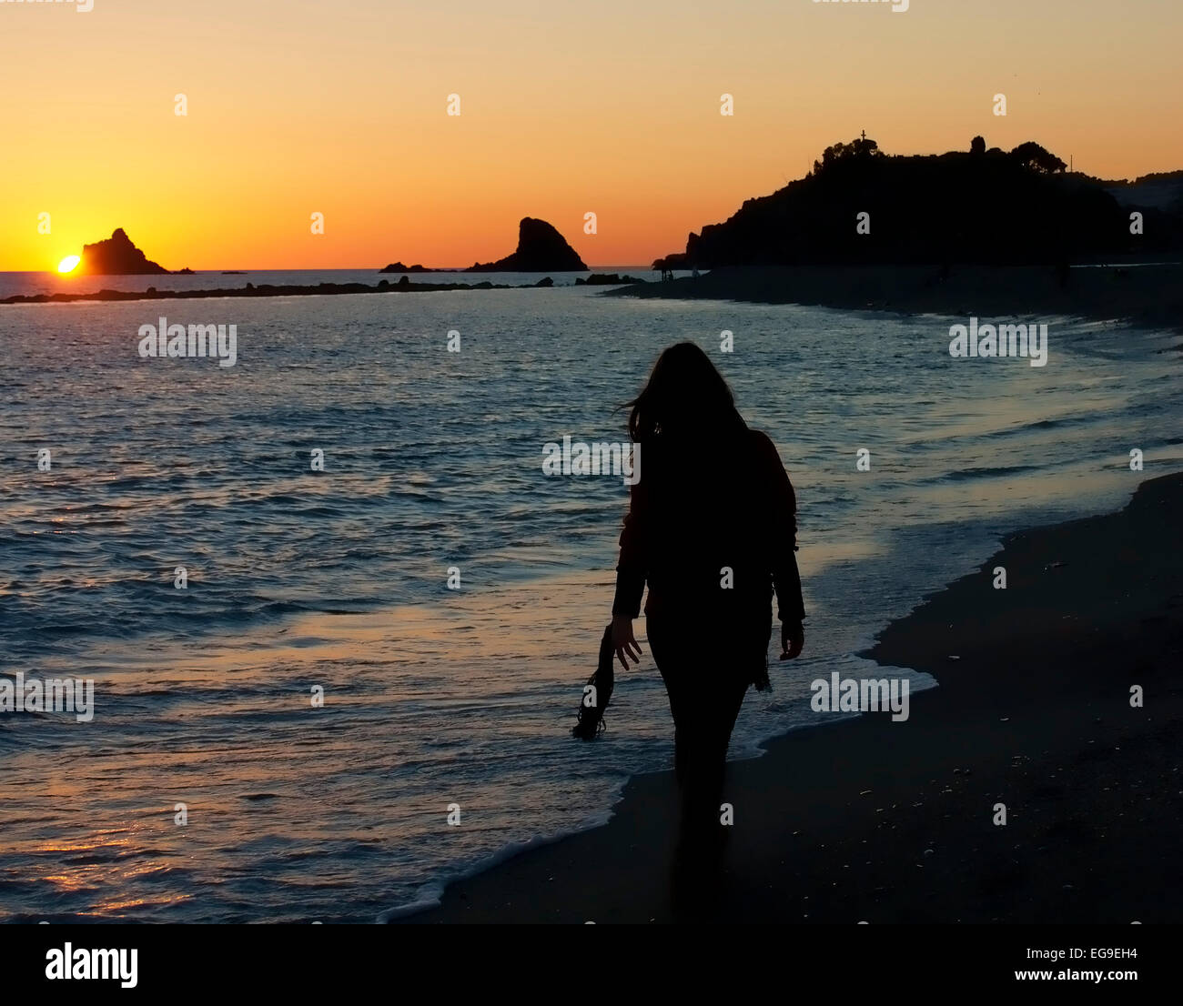 Silhouette of a woman walking on beach at sunset Stock Photo - Alamy