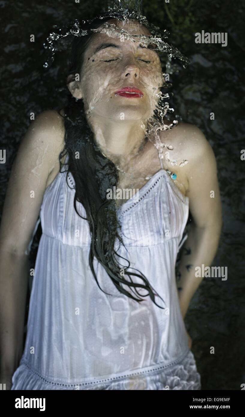 Portrait of a woman in a dress lying underwater in a water fountain