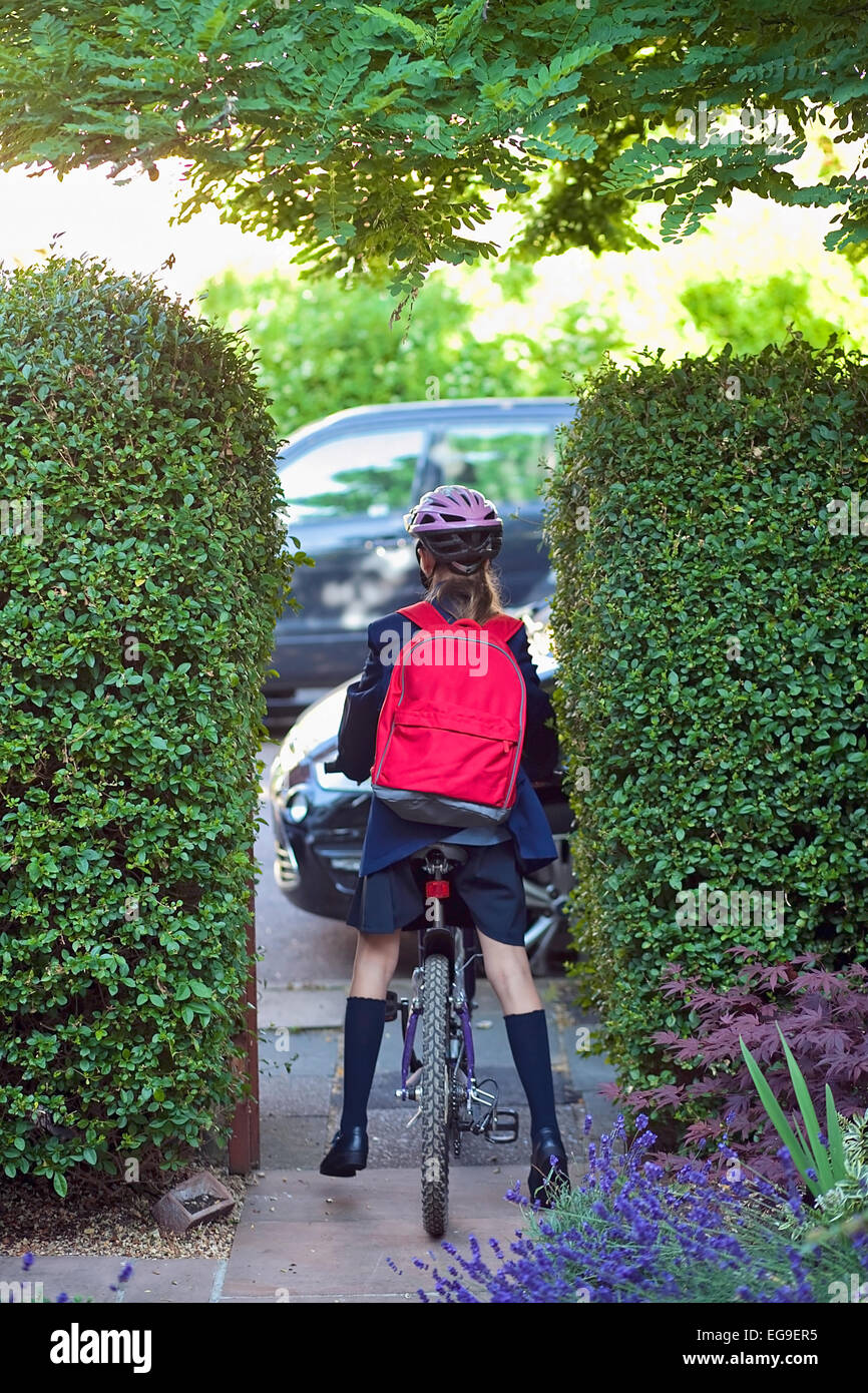 Young girl (12-13) going to school on bike Stock Photo