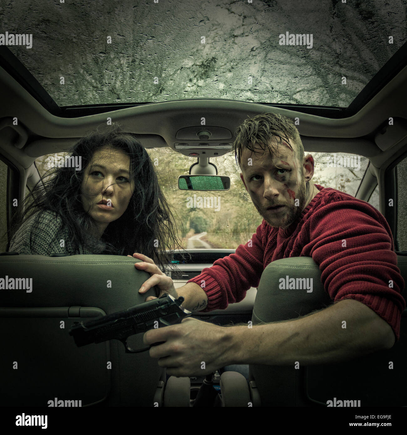 Man and woman in car with handgun Stock Photo