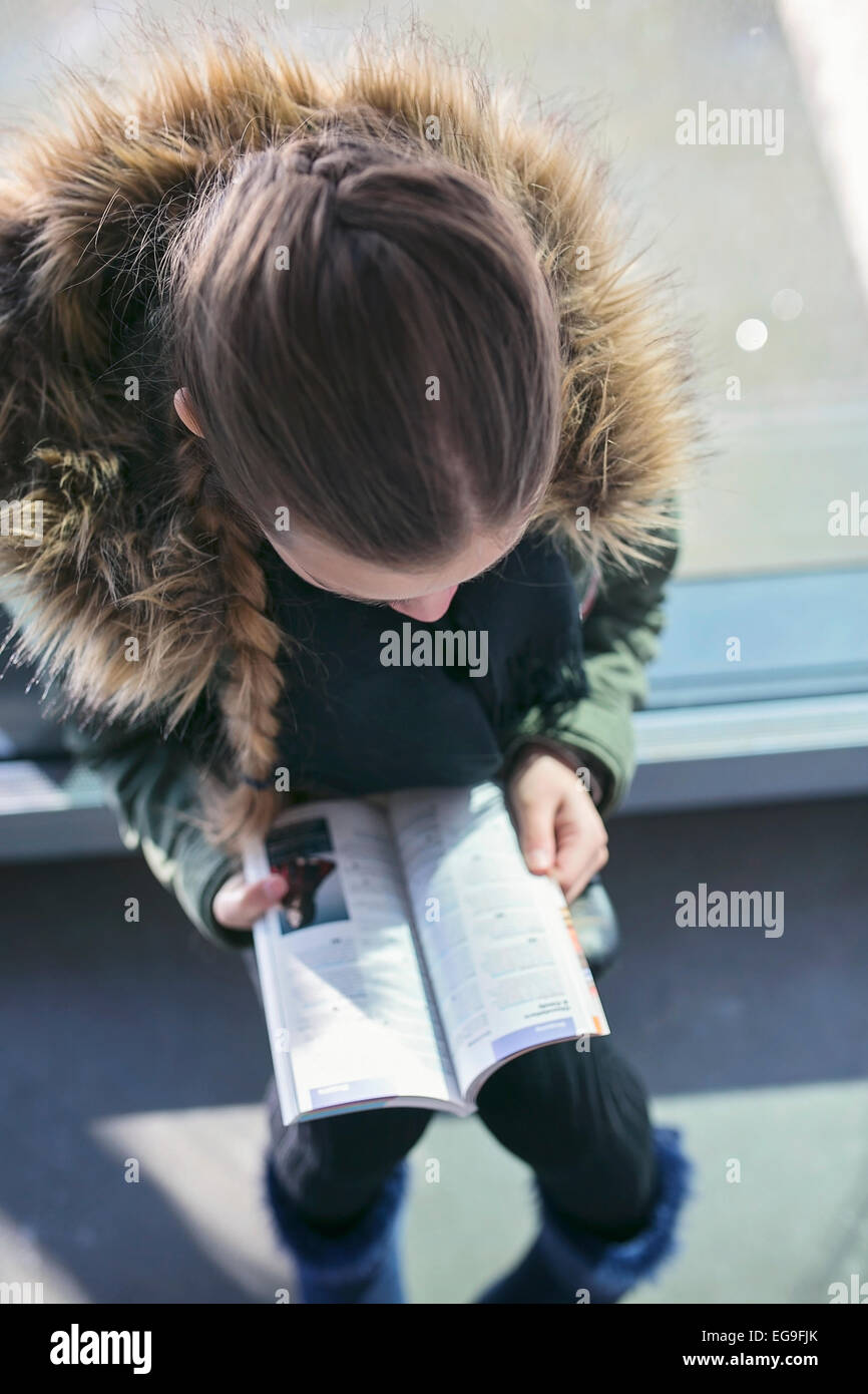 Teen girl (14-15) reading tourist guide book Stock Photo