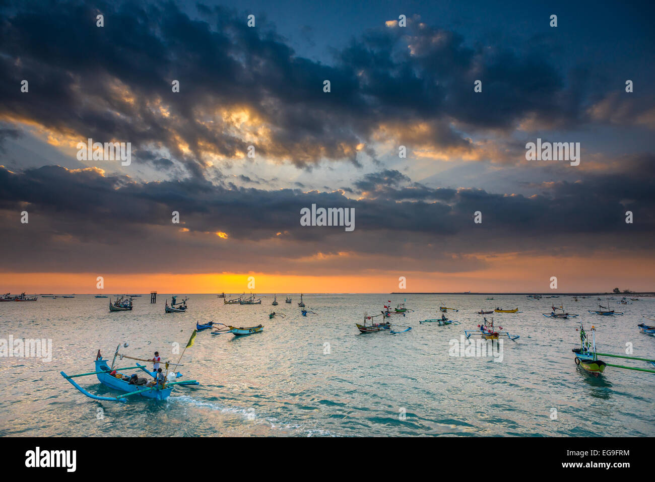 Indonesia, Bali, Jimbaran Bay, Fishing boats heading out at sunset Stock Photo