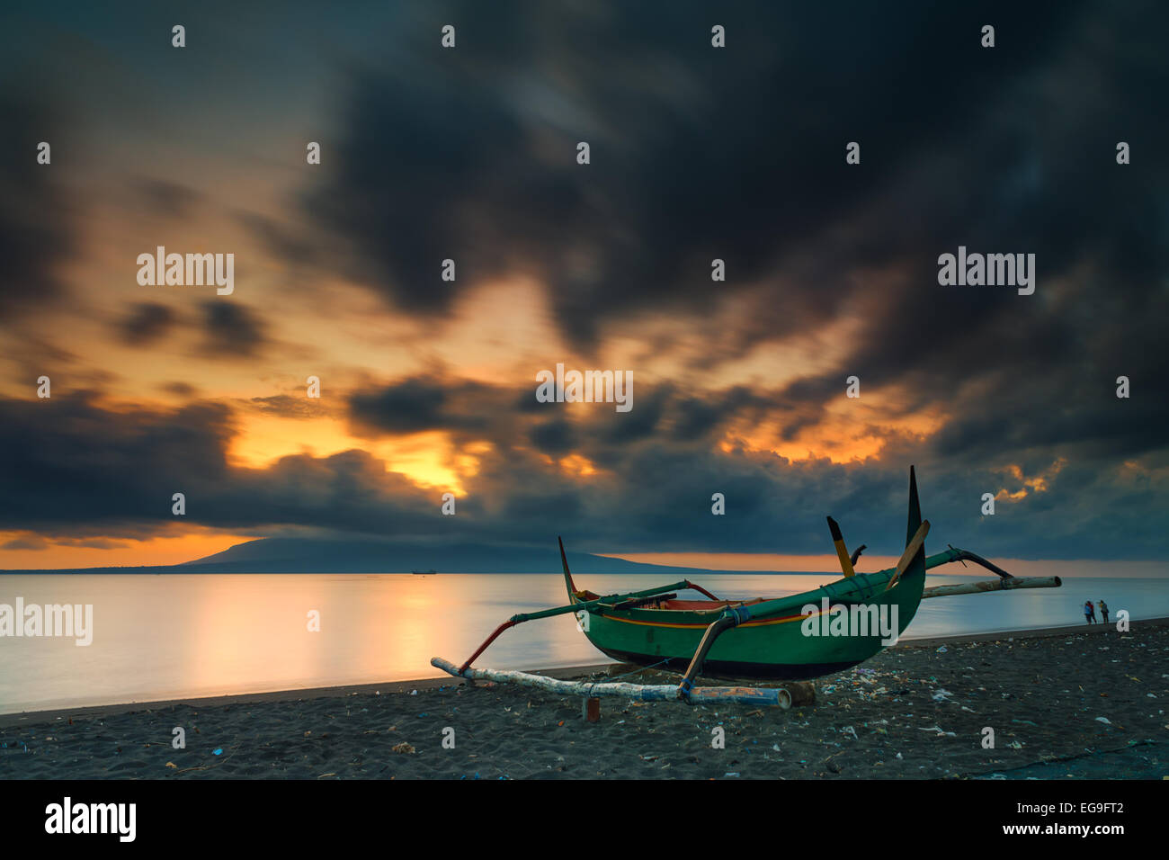 Indonesia, Banyuwangi, Santen Island, Sunrise on beach with fishing boat in foreground Stock Photo