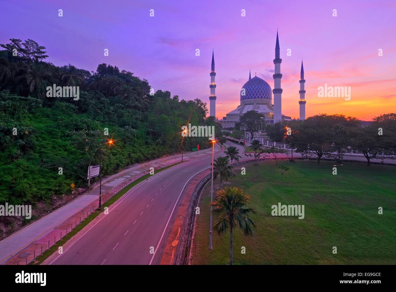 Malaysia, Kuala Lumpur, Empty road with Blue Mosque on background at dusk Stock Photo