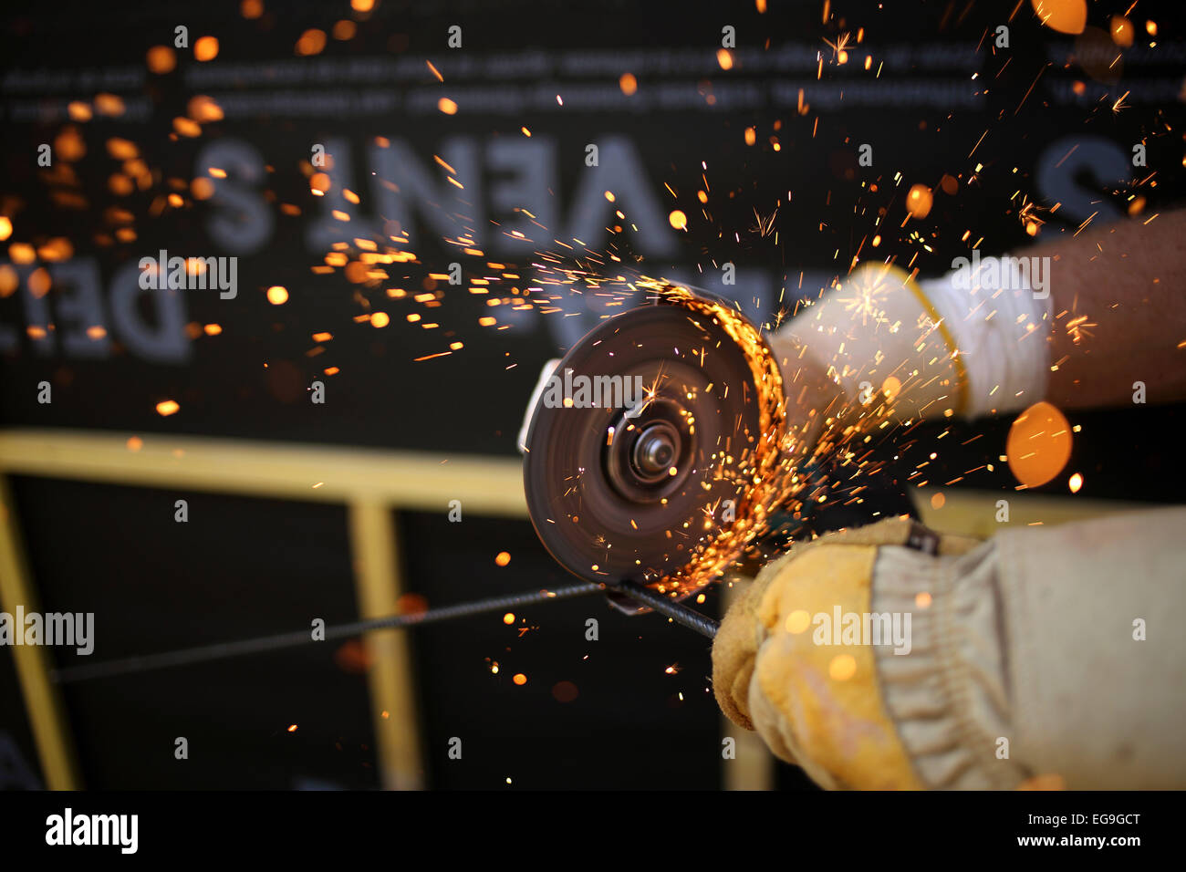 Close up of man using sanding tool on metal Stock Photo